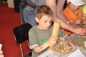 ﻿Ein junger Besucher füllt ein Bambusröhrchen﻿